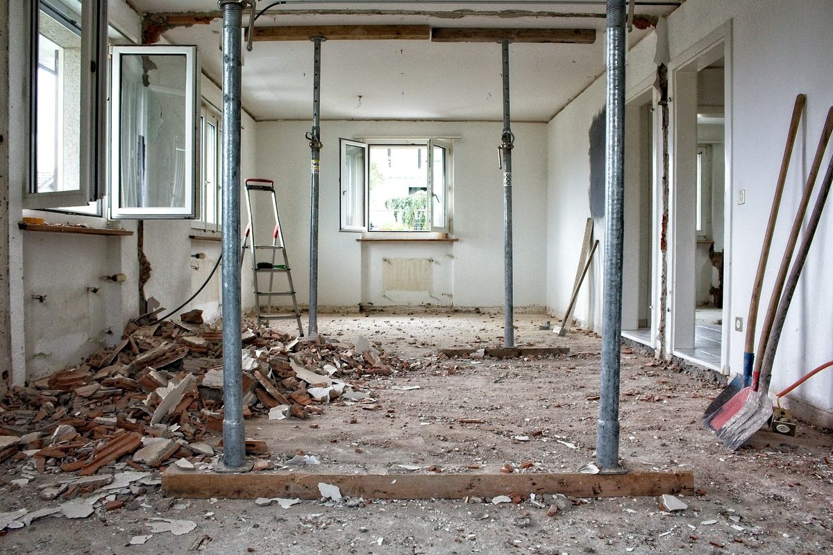 Een woonkamer in verbouwing: muren uitgebroken, het plafond gestut met stempels